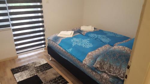 a bed with two towels on it in a room at Apartman Košuta 2 in Tjentište