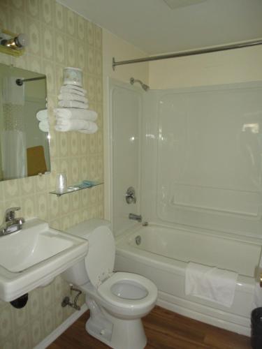 a bathroom with a toilet and a sink and a tub at Sorrento Inn Motel in Sorrento