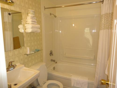 a bathroom with a tub and a toilet and a sink at Sorrento Inn Motel in Sorrento