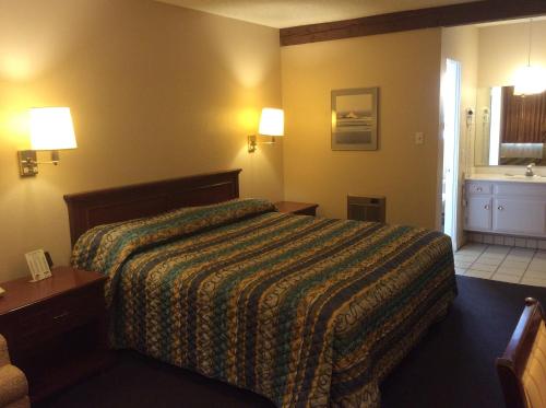 Habitación de hotel con cama y baño en Torch Lite Lodge en Yuma