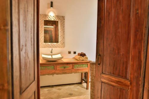 a bathroom with a sink and a mirror on a table at Apalagi Villas in Gili Air