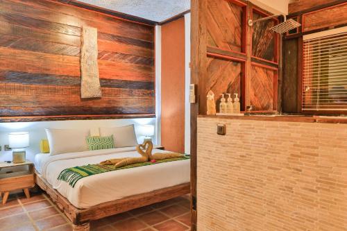 a bedroom with a bed with a wooden wall at Apalagi Villas in Gili Air