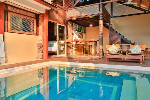 a swimming pool in a room with a house at Apalagi Villas in Gili Air