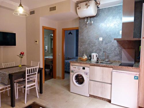 een keuken met een wasmachine en een wastafel bij Najera Suite in Antequera