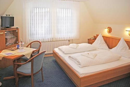 ein Hotelzimmer mit einem Bett und einem Tisch in der Unterkunft Haus Thorwarth - Hotel garni in Cuxhaven