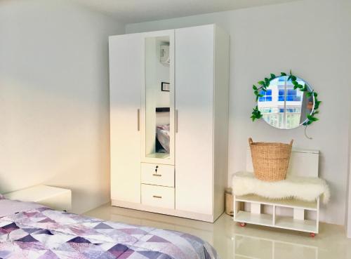 1 dormitorio con armario blanco y silla en Grandbeach Condo Unite A307 en Rayong