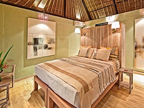 een slaapkamer met een groot bed in een kamer bij Puri Darma Agung Villa in Ubud