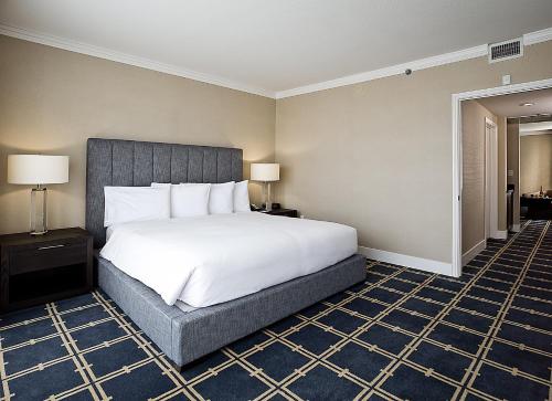 a bedroom with a large bed with white sheets at Grand Hotel in Sunnyvale