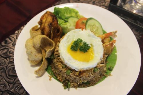 a plate of food with an egg on top at Royale Signature Hotel in Alor Setar