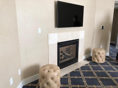 a living room with a fireplace with a tv above it at Grand Hotel in Sunnyvale