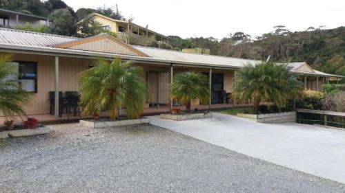 un bâtiment avec des palmiers en face de celui-ci dans l'établissement Whatuwhiwhi TOP 10 Holiday Park, à Tokerau Beach