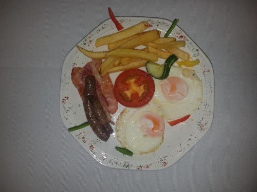 a plate of food with eggs sausage and french fries at The Spotted Grunter Resort in Port St Johns
