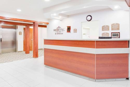 a lobby of a hotel with a reception counter at Microtel Inn & Suites by Wyndham Olean in Olean