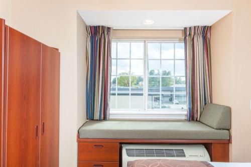 a window seat in a bedroom with a window at Microtel Inn by Wyndham Rogers in Rogers