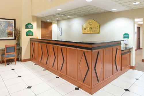 a lobby of a newark hospital with a welcome sign on the counter at Wingate by Wyndham Erlanger - Florence - Cincinnati South in Erlanger