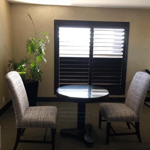 two chairs and a table in a room with a window at Cupertino Hotel in Cupertino