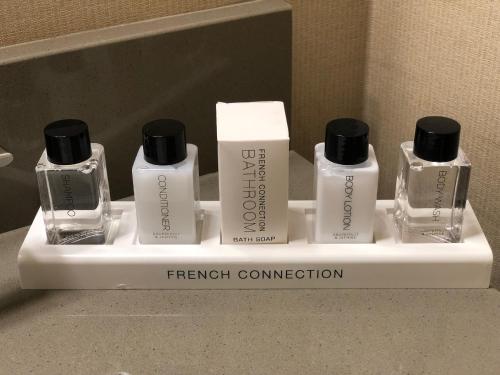 a group of four bottles of french connection on a shelf at Cupertino Hotel in Cupertino