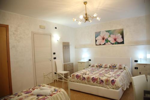 sypialnia z 2 łóżkami i żyrandolem w obiekcie À La Maison De Gabry w mieście Vibo Marina