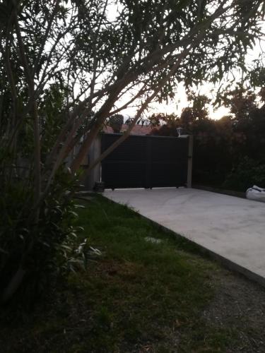 a backyard with a fence and a driveway at Villa de charme avec piscine in Ghisonaccia