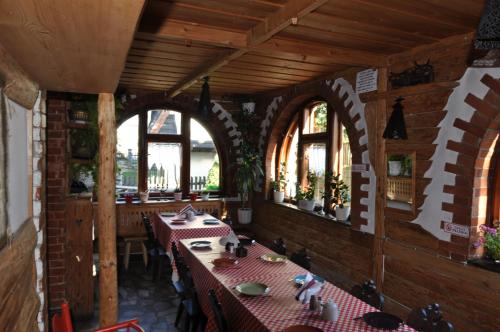 a restaurant with long tables in a room with windows at Willa Stella in Kościelisko