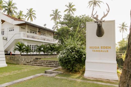 a sign in front of a hotel with a deer head on it at Nuga Eden Tangalle in Tangalle