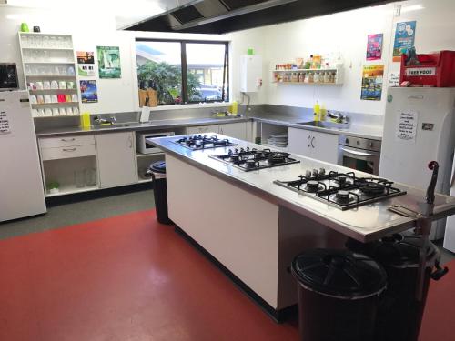 a kitchen with a stove top oven and a counter top at Rainbow Lodge Backpackers in Taupo