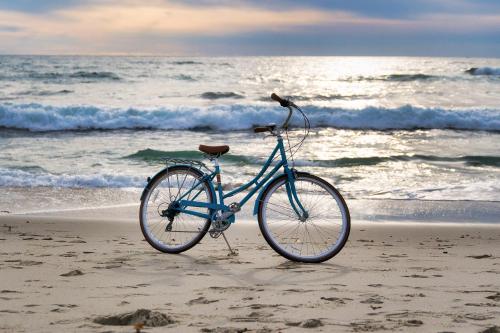 a bike parked on the beach near the ocean at LOGIS Hotel Majestic Chatelaillon Plage - La Rochelle in Châtelaillon-Plage