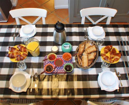 - une table avec de la nourriture pour le petit-déjeuner sur un tissu de table en damier dans l'établissement La Bruyère - chez Martine, à Appy