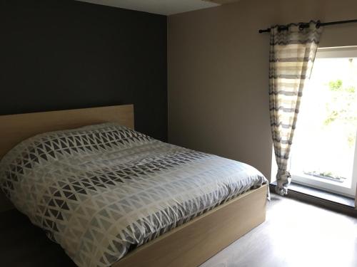 a bed in a bedroom with a window at Le gîte du faubourg in Sautour
