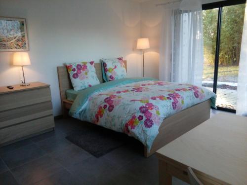 a bedroom with a bed and a dresser and a window at Boizen in Saint-Jean-de-Boiseau