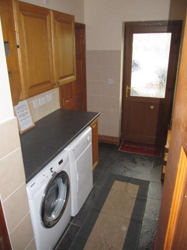 a laundry room with a washing machine and a door at Nant-Y-Glyn in Llandrindod Wells
