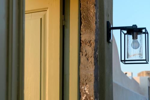 a door with a light on the side of a building at Phaos 1870, A restored Winery in Pirgos