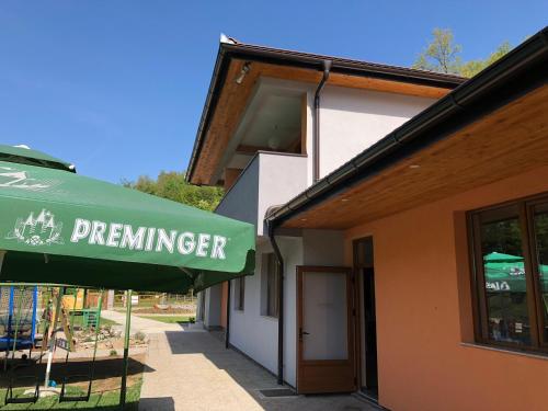a green umbrella in front of a building at Motel "KULA" in Cazin