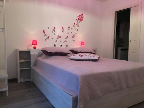 ジェラールメにあるGerardmer : Residence "l'eau vive"のベッドルーム1室(花の壁掛けのベッド1台付)