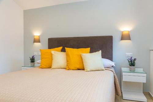 a bedroom with a large bed with yellow pillows at Hotel Rivoli Sorrento in Sorrento