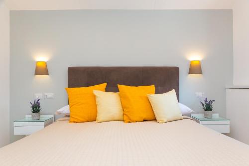 a bedroom with a large bed with yellow pillows at Hotel Rivoli Sorrento in Sorrento
