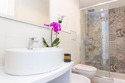 a bathroom with a sink and a toilet and a shower at Hotel Rivoli Sorrento in Sorrento