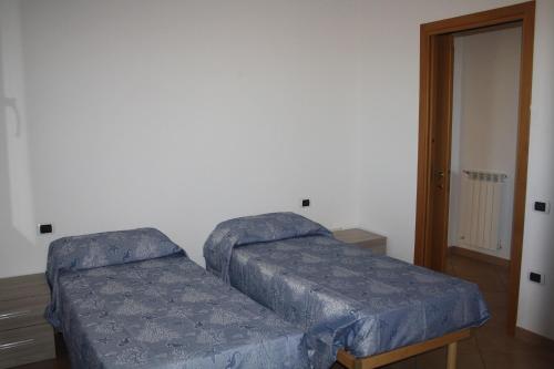 a bed in a room with a blue cover at Il Giardino in Riotorto