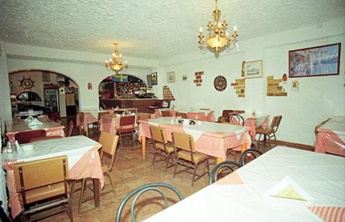 uma sala de jantar com mesas e cadeiras num restaurante em Pansion Alexandros em Pelekas