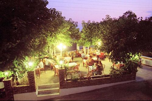 a group of people sitting in a patio at night at Pansion Alexandros in Pelekas