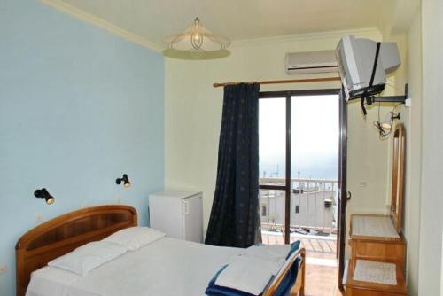 a bedroom with a bed and a window with a view at Pansion Alexandros in Pelekas