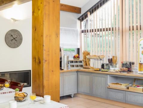 a kitchen with a counter and a clock on the wall at Les Chalets des Chatelminés in La Bresse