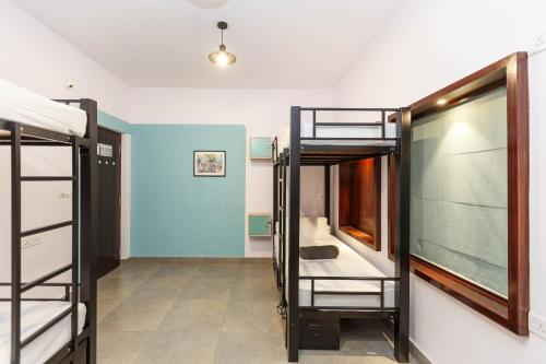 a room with three bunk beds and a hallway at Locul Uptown - Near Bangalore Palace Grounds in Bengaluru