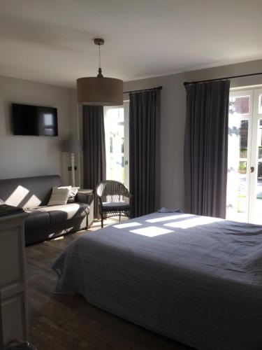 a bedroom with a bed and a couch at BB-hof ter boone in Kapelhoek