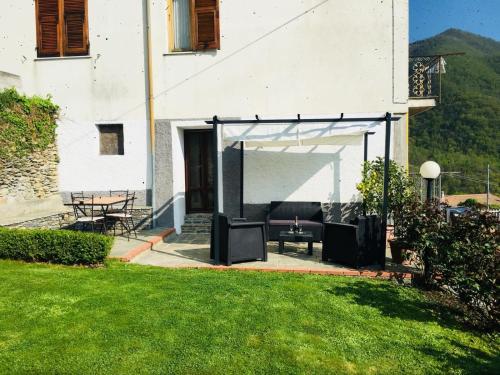 a patio with a tent and a table in a yard at Green House in Pieve di Teco