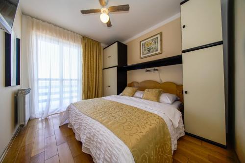 a bedroom with a large bed and a ceiling fan at Porto Romantico 2 in Sveti Juraj