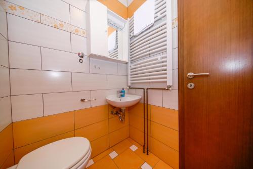 a bathroom with a toilet and a sink at Porto Romantico 2 in Sveti Juraj