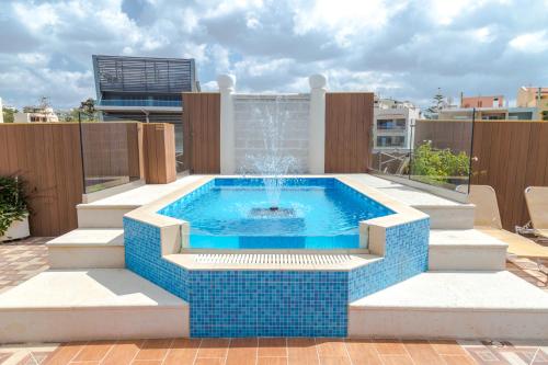 a swimming pool with a fountain on a patio at Halepa Hotel in Chania