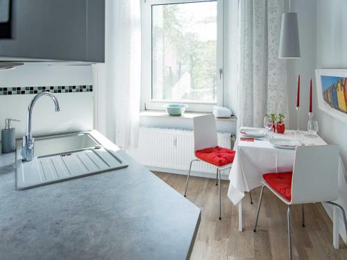 a kitchen with a sink and a table with chairs at Stadtvilla B in Neustadt in Holstein