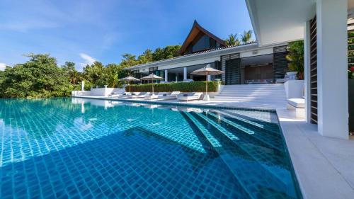 a swimming pool in front of a house at Ocean's 11 Villa in Ban Pa Khlok